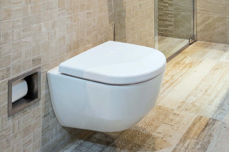 Moderní koupelna se závěsným záchodem a integrovaným držákem toaletního papíru