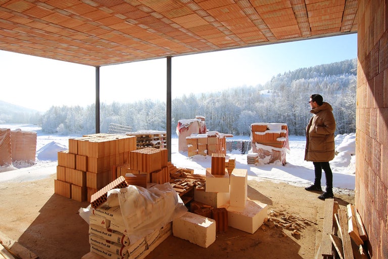 Staveniště s cihlami a výhledem na zasněženou krajinu