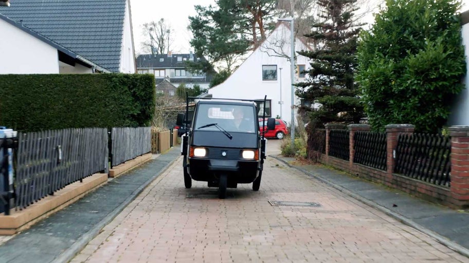 Malý dodávkový vůz Piaggio Ape jede po dlážděné silnici