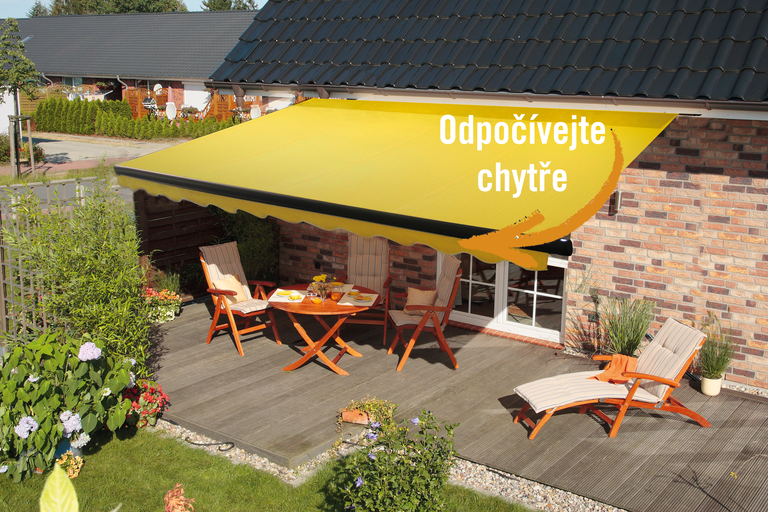 Žlutá kloubová markýza nad terasou se zahradním nábytkem.
