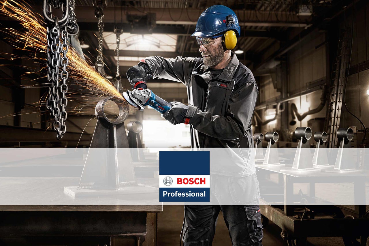 Muž s helmou a chrániči sluchu brousí kovovou trubku úhlovou bruskou, logo Bosch Professional