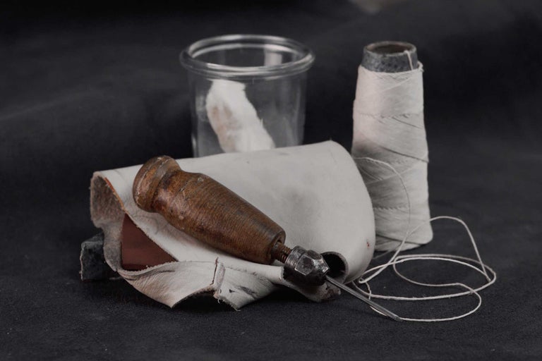 Šídlo s dřevěnou rukojetí, kůže a cívka nitě