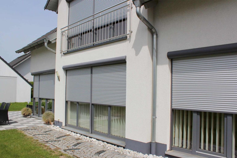 Fasáda domu se staženými roletami