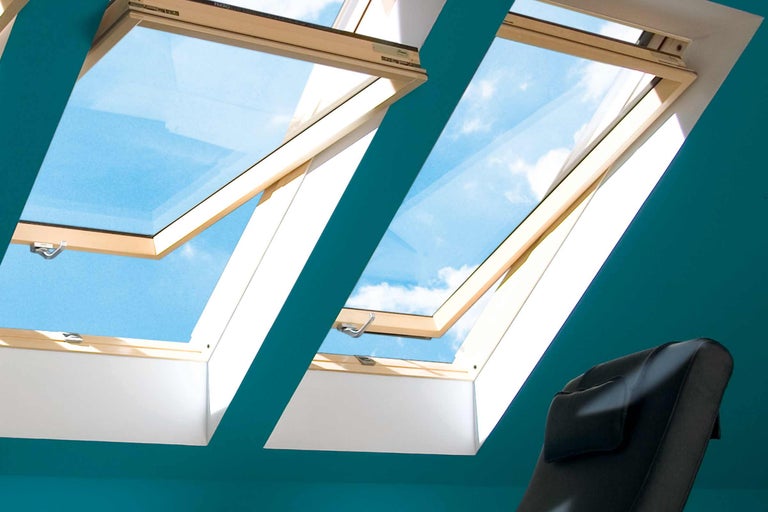 Dvě otevřená střešní okna s výhledem na oblohu