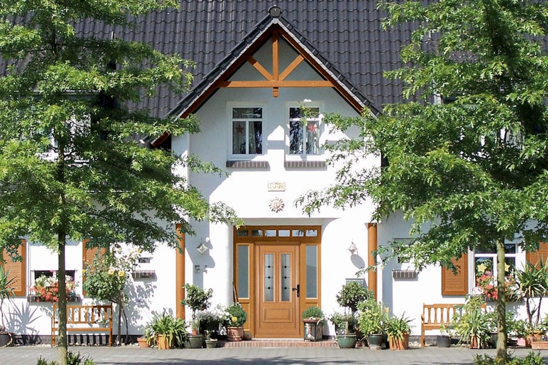 Pohled na dům s vchodovými dveřmi, okny a rostlinami