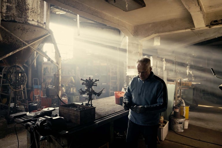 Dílna s pracovním stolem, nářadím a pracujícím mužem