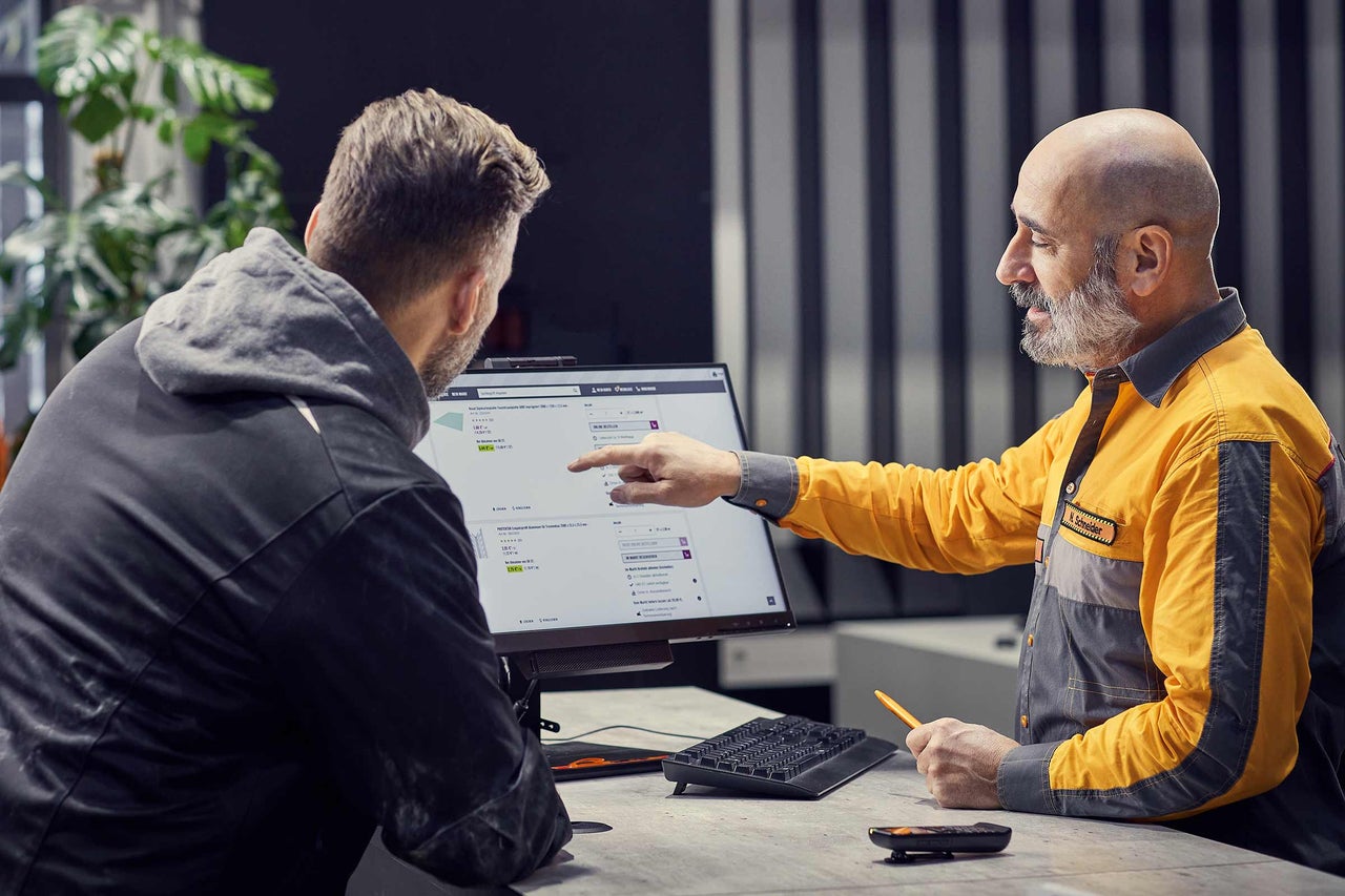 Pracovník Hornbach radí zákazníkovi s produkty na počítači.