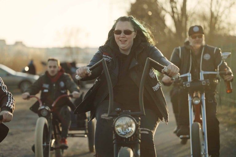 Skupina lidí jezdí na kolech s motorovou asistencí.