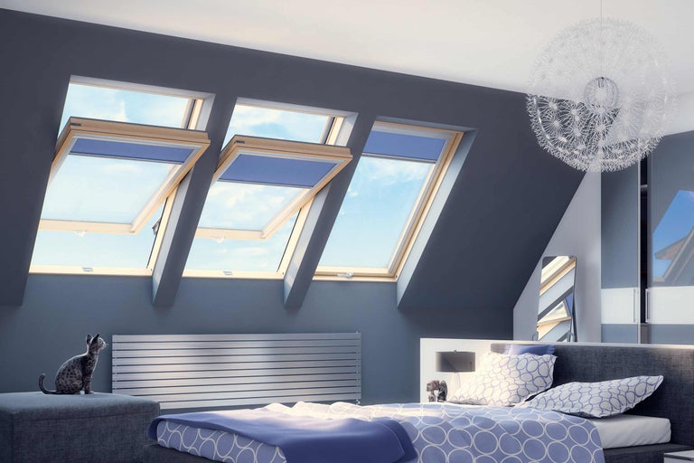 Světlá ložnice se střešními okny, radiátorem a ozdobnou lampou