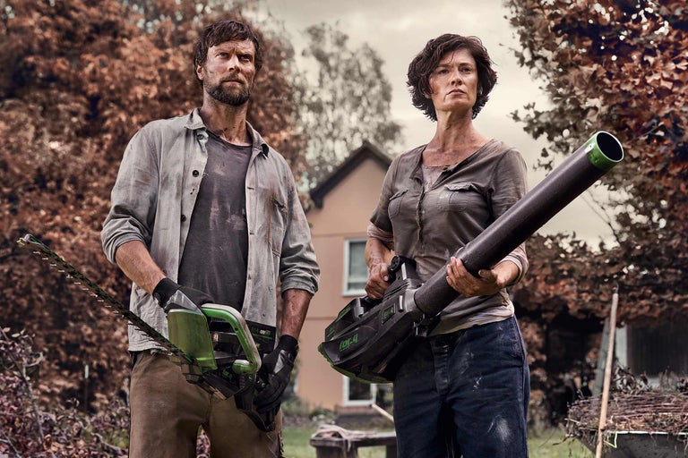 Muž drží nůžky na živý plot a žena drží venkovní foukač listí.