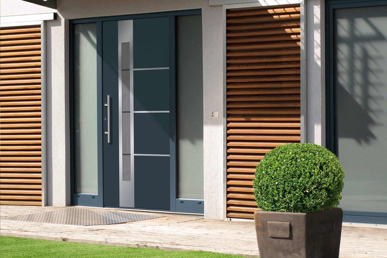 Moderní vchodové dveře se skleněnými prvky a nerezovou klikou v světlém domě