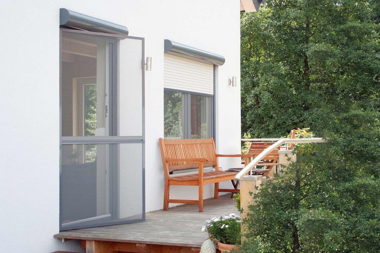 Fasáda domu s dveřmi proti hmyzu a roletami