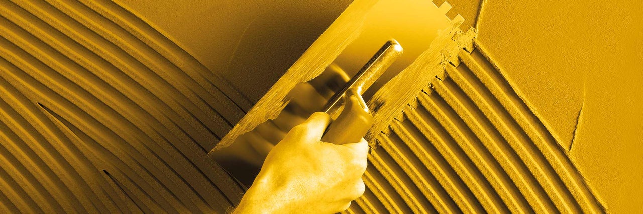 Nanášení lepidla na obklady pomocí lžíce