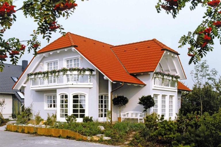 Rodinný dům s červenou taškovou střechou a kvetoucími balkony