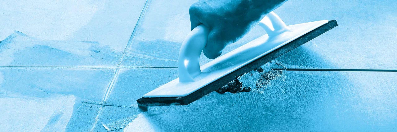 Obkladač pracuje s gumou na spáry