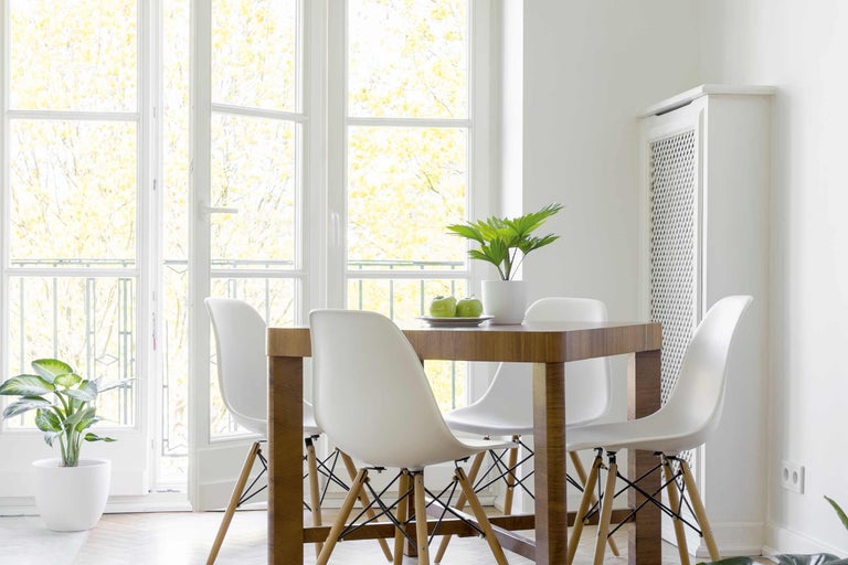 Světlá jídelna s dřevěným stolem a bílými židlemi