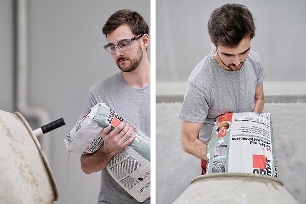 Muž sype betonovou směs do míchačky na beton