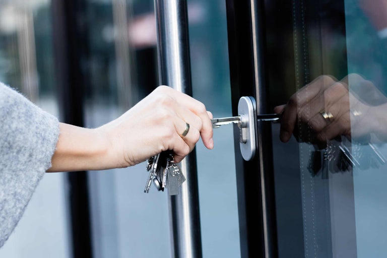 Osoba odemyká dveře klíčem