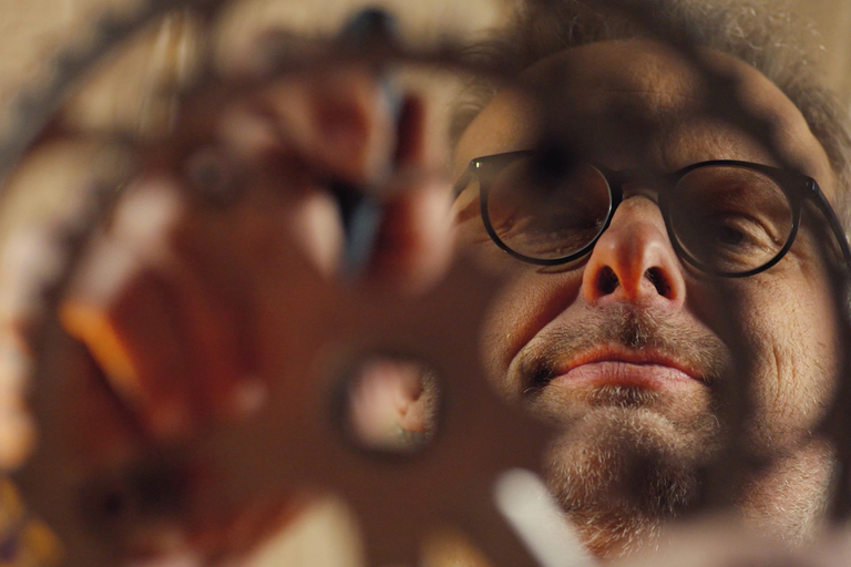 Muž s brýlemi se dívá skrz nástroj
