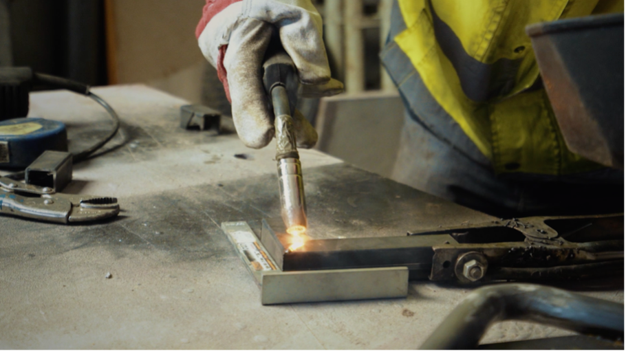 Svařování kovu se svářečkou na pracovním stole