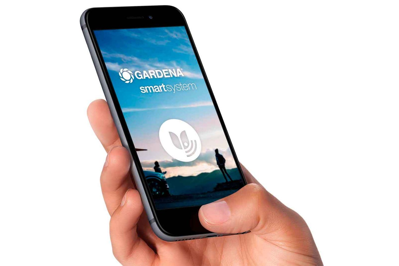 Ruka drží smartphone s aplikací Gardena Smart System