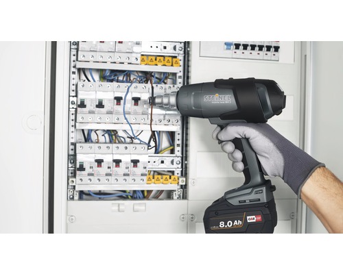 Elektrikář používá horkovzdušnou pistoli Steinel Mobile Heat MH3 na rozvodné skříni