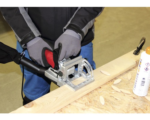 Osoba používá lamelovací frézku na dřevěné desce.