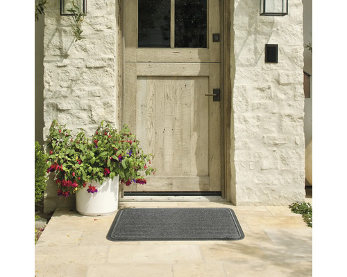 Exteriér s šedou rohožkou před vchodovými dveřmi