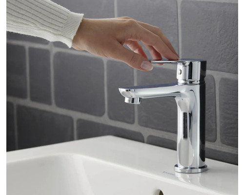 Ruka ovládá armaturu na umyvadle