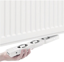 Osoba drží ventilátor radiátoru pod radiátorem.
