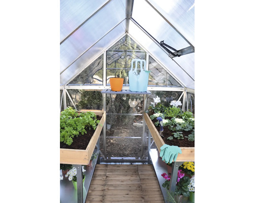 Interiér skleníku s rostlinami a zahradním nářadím