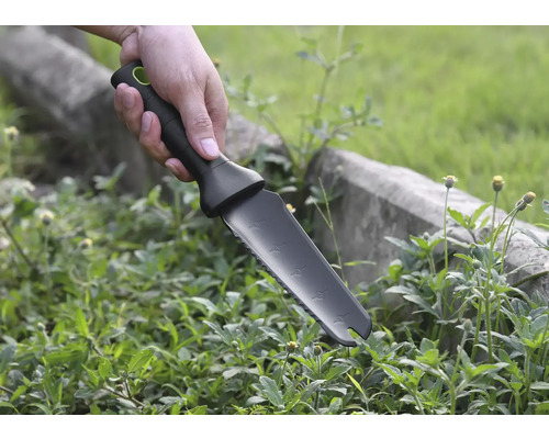 Ruka drží zahradní nůž na pletí plevele.