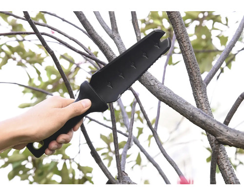 Ruka drží multifunkční zahradní sekeru používanou na větvi