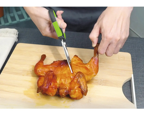 Kuře se krájí kuchyňskými nůžkami na prkénku.