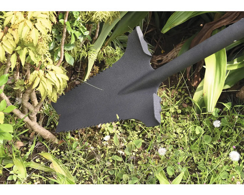 Zahradní rýč se zuby pily na zahradě.