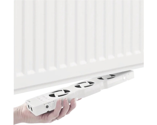 Osoba instaluje ventilátor radiátoru na radiátor.