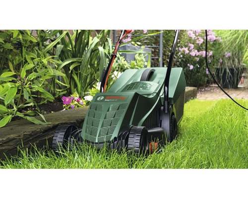 Sekačka na trávu používaná v zahradě mezi rostlinami