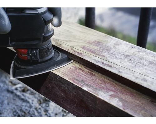 Trojúhelníková bruska brousí kus dřeva