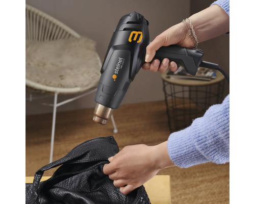 Horkovzdušná pistole používaná na koženou tašku