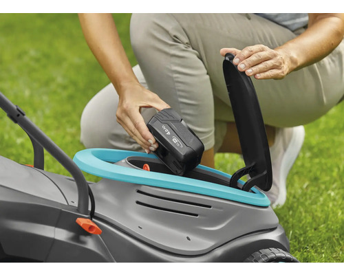 Osoba vkládá 4,0Ah baterii do sekačky na trávu