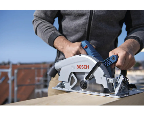 Muž řeže dřevěnou desku ponornou pilou Bosch