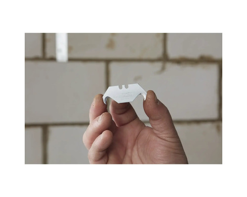 Osoba drží lichoběžníkovou čepel pro řezací nůž