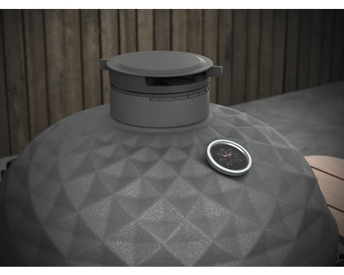 Detailní pohled na gril kamado s ukazatelem teploty a strukturovaným keramickým povrchem