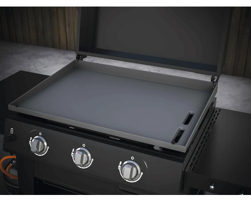 Gril s grilovací deskou a ovládacími knoflíky