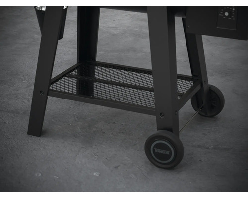 Detailní pohled na podstavec černého grilu na pelety s úložným prostorem a kolečky