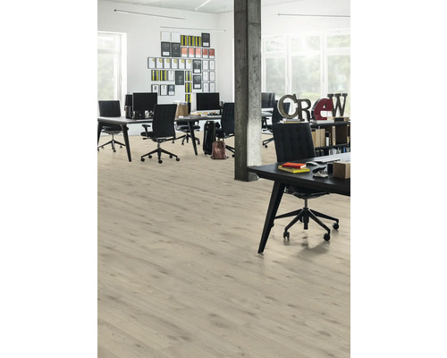 Světlá kancelář s dřevěnou podlahou, stoly a kancelářskými židlemi.