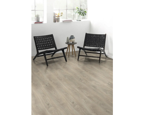 Dvě černá proutěná křesla a odkládací stolek s vázami ve světlé místnosti