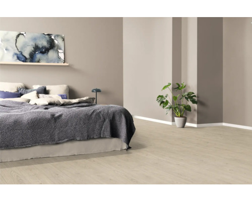 Ložnice s postelí, obrazem a pokojovou rostlinou na světlé dřevěné podlaze