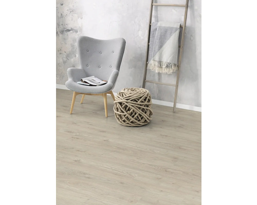 Obývací pokoj s křeslem, pleteným míčem a dřevěným žebříkem s dekou na laminátové podlaze