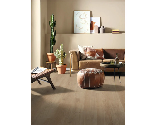 Světlý obývací pokoj s pohovkou, polštáři, rostlinami a dřevěnou podlahou